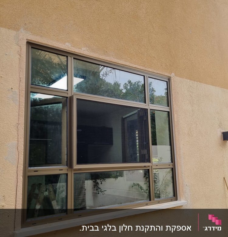 חלון אלומיניום עם מסגרת חומה על קיר חיצוני